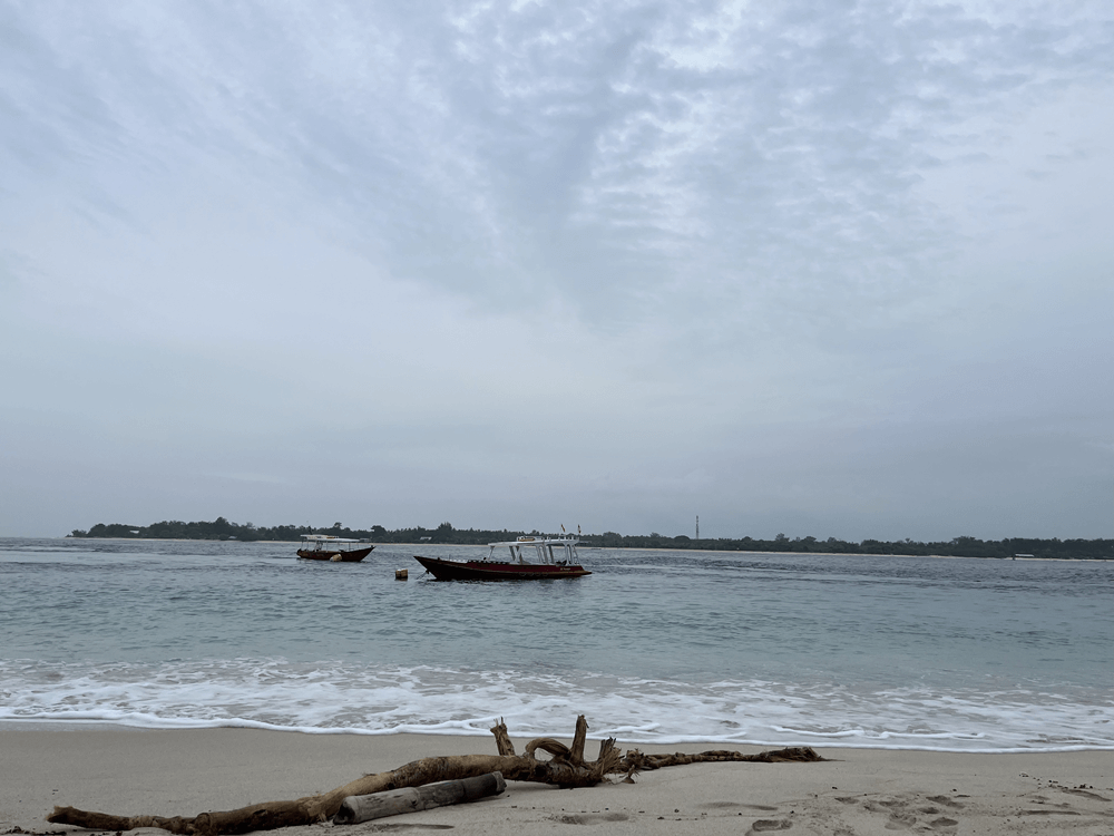 Scenic view of Gili Trawangan Sunset Beach with golden sky and calm waves, a favorite spot for travelers in Indonesia