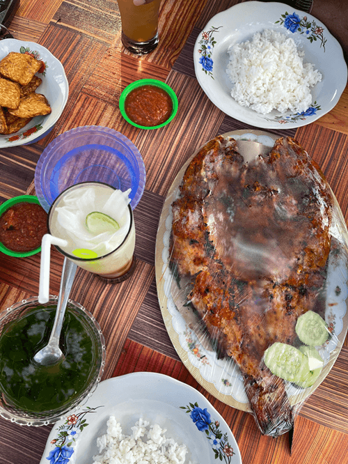 Grilled seafood with rice and local dishes served on a table, representing Gili Air best restaurants and authentic island dining experience