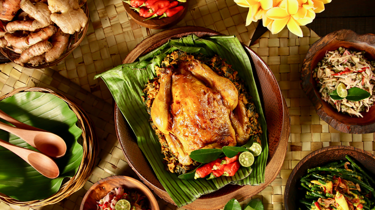 Traditional Balinese Ayam Betutu served with local side dishes, one of the best food in Bali experiences for travelers.