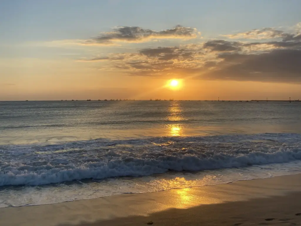 What is the best weather in Bali for enjoying a beautiful sunset and clear skies at the beach?