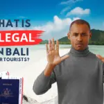 What Is Illegal in Bali for Tourists – traveler raising both hands with a Bali beach and temple in the background.