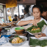 What to Know About Eating Street Food in Bali, featuring a local food vendor preparing traditional Balinese food at a street stall.